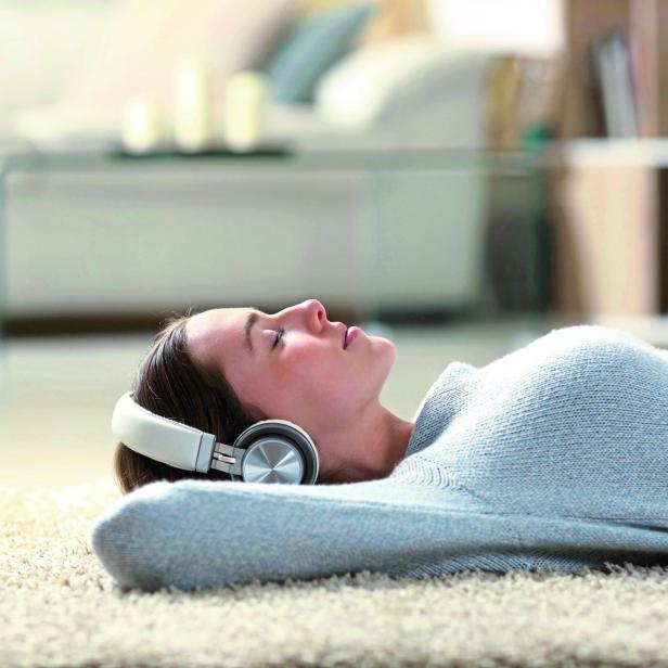 Relaxed woman listening to music with headphones at home