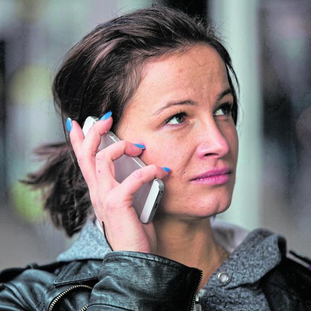 FILE PHOTO: A woman uses a mobile phone in north London