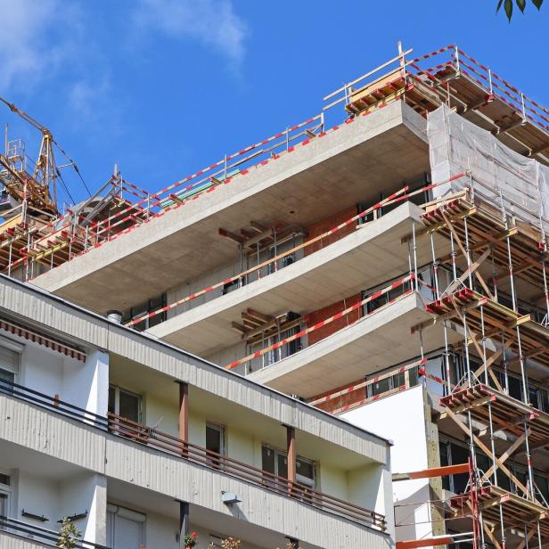 Ein Gebäude im Bau mit einem Kran im Hintergrund.