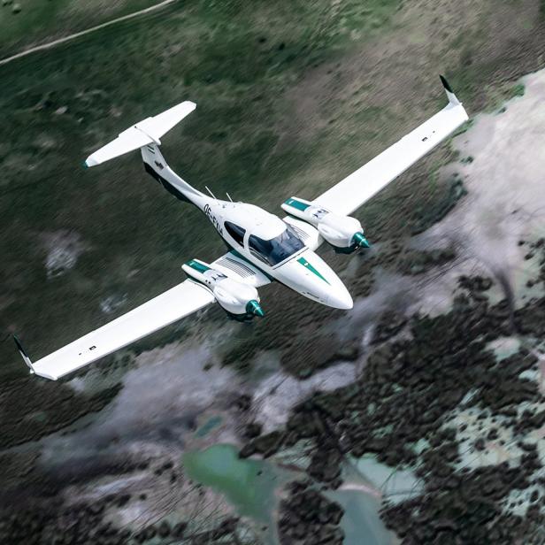 Diamond Aircraft DA 42 Kleinflugzeug über einer grünen Landschaft