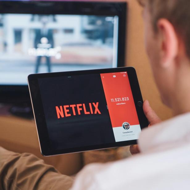 Mann  mit Tablet mit Netflix-App