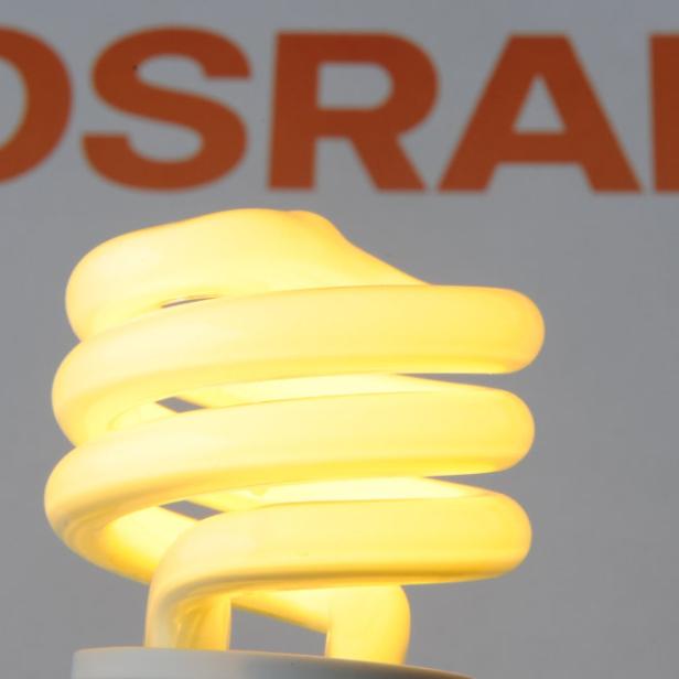 ILLUSTRATION - Eine Energiesparlampe von Osram leuchtet am Dienstag (29.03.2011) in Straubing (Niederbayern) vor dem Firmenschriftzug .Die Siemens AG verordnet sich kaum ein halbes Jahr nach dem Ende des jüngsten Umbaus eine neue Struktur. Dazu gehört auch ein Börsengang der profitablen Lichttochter Osram GmbH. Osram erwirtschaftete zuletzt mit rund 40.000 Mitarbeitern einen Umsatz von 4,7 Milliarden Euro. Foto. Armin Weigel dpa/lby +++(c) dpa - Bildfunk+++