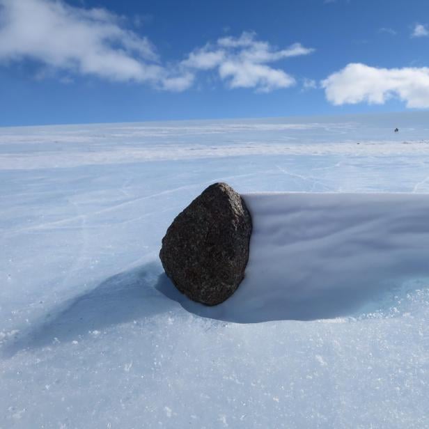 Ein schwarzer Meteorit in der Antarktis. Wegen dem Klimawandels könnten die Himmelskörper schon bald im Meer verschwinden. 