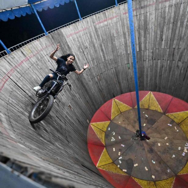 Stuntfrau auf einem Motorrad auf einer "Wall of Death"