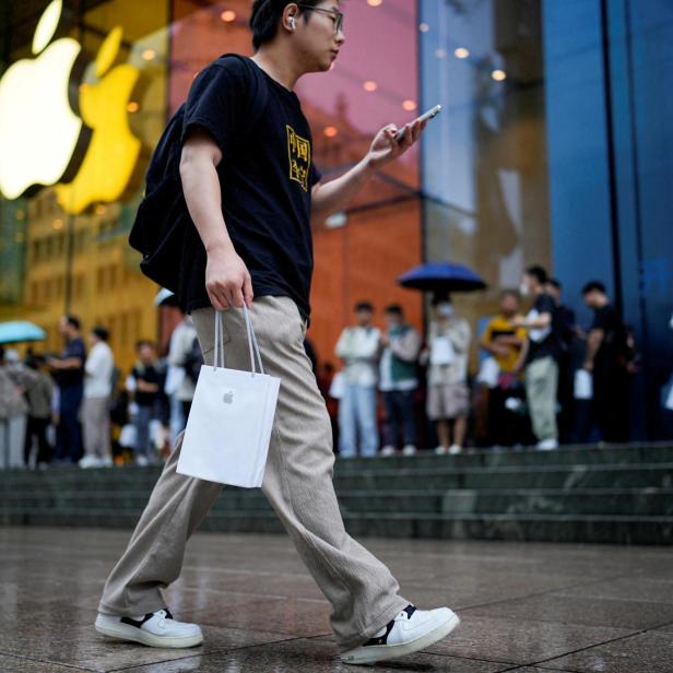 Ein Mann trägt Apples iPhone 15 in einer Tasche in Shanghai, China.