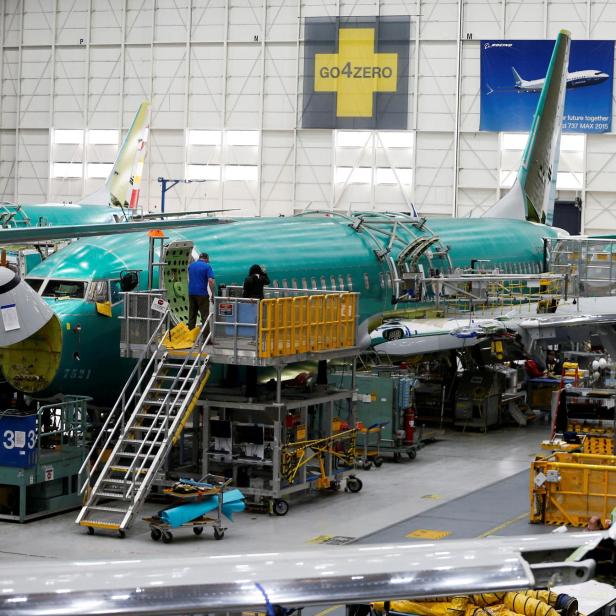 FILE PHOTO: People work near the door of a 737 Max aircraft at the Boeing factory in Renton