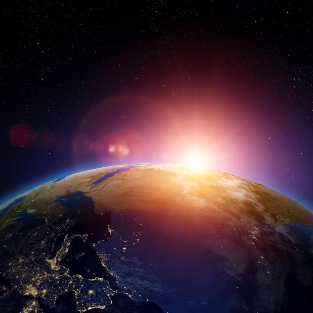 Ein Sonnenaufgang über der Erde, mit Blick auf Europa bei Nacht.