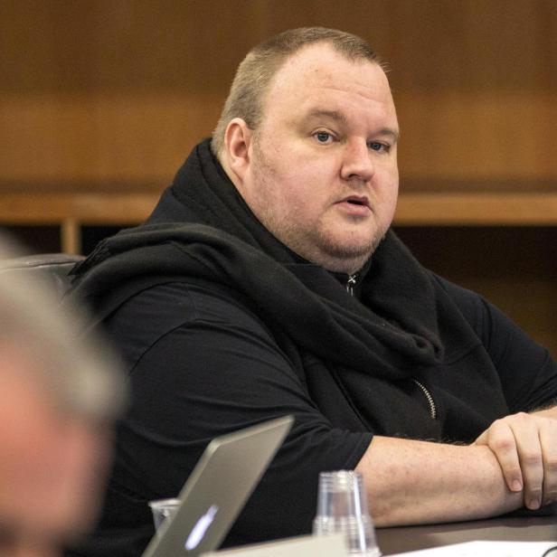 FILE PHOTO: German tech entrepreneur Kim Dotcom sits in a chair during a court hearing in Auckland, New Zealand