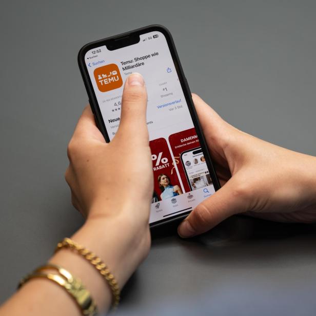 Eine Person installiert die Temu-App auf einem Smartphone.