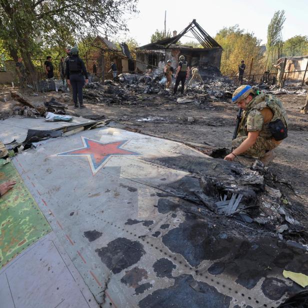 Ukrainische Soldaten inspizieren das Wrack der S-70 Okhotnik