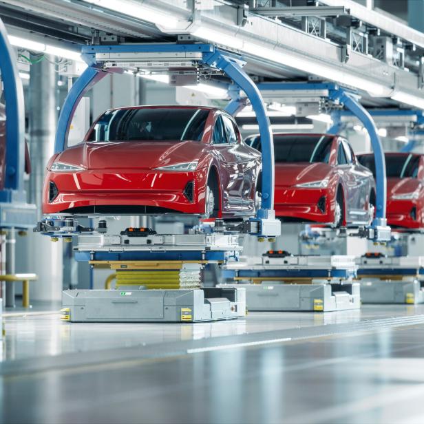 Eine Reihe roter Autos auf einer Produktionslinie in einer Fabrik.