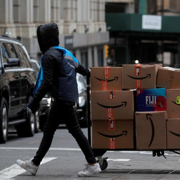 An Amazon delivery worker pulls a cart full of boxes for delivery on Cyber-Monday in New York