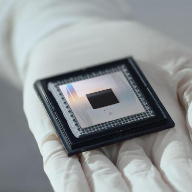 Eine Hand in einem weißen Handschuh hält einen Quantenchip.