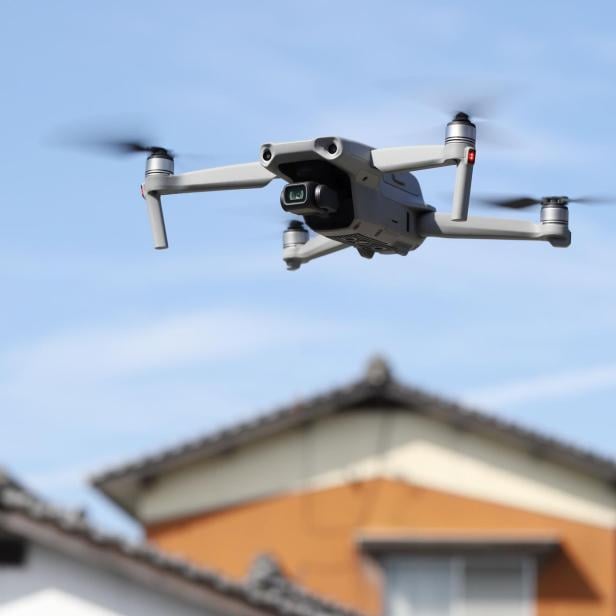 Eine Drohne fliegt in der Nähe eines Wohnhauses.