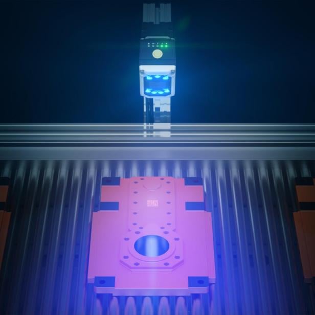 Eine Maschine mit einem optischen Sensor untersucht ein Bauteil.