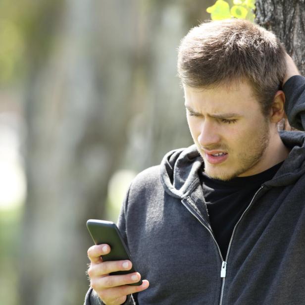 Mann schaut besorgt auf sein Smartphone