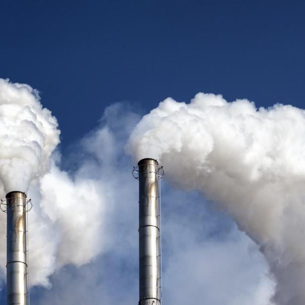 Industrieschornsteine mit dichten weißen Abgaswolken