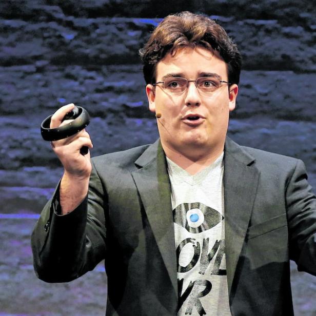Ein Mann mit Brille hält zwei VR-Controller in den Händen.