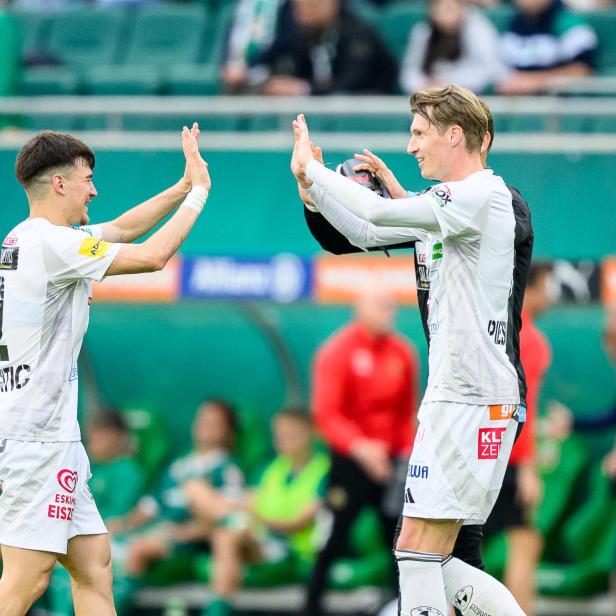 zwei Spieler im Fußball-Dress klatschen sich ab