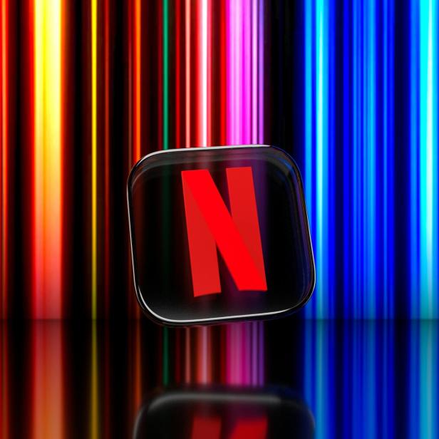 Das Netflix-Logo vor einem farbenfrohen, vertikal gestreiften Hintergrund.