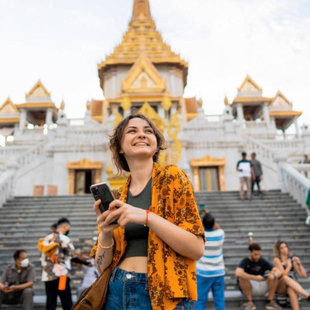 Frau mit Handy in Thailand