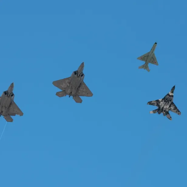 2 F-22 neben einer MiG-21 und einer MiG-29 (r.).