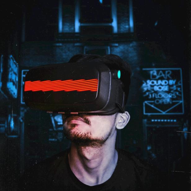 Ein Mann trägt ein Virtual-Reality-Brille in einem dunklen Raum.