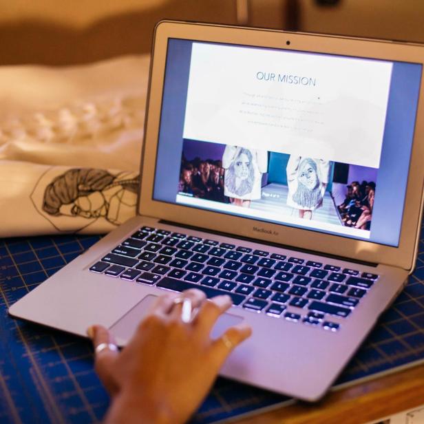  Eine Person sitzt an einem Schreibtisch und arbeitet mit einem Laptop.