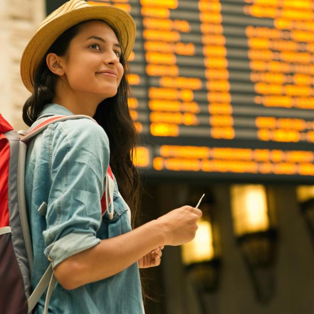 Young woman checking her train in time board
