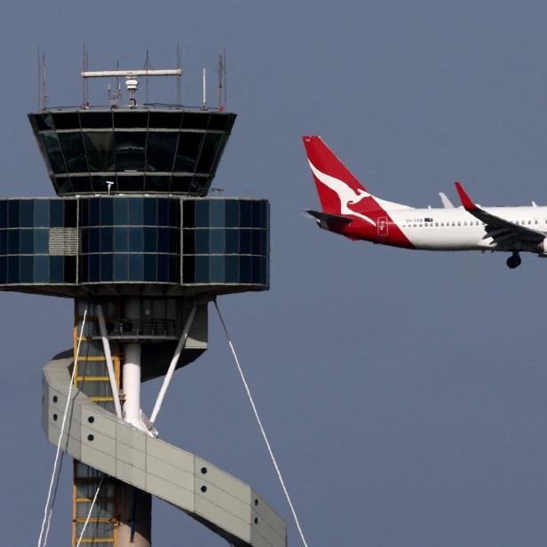 Ein Flugzeug fliegt am Tower des Flughafens von Sydney vorbei.