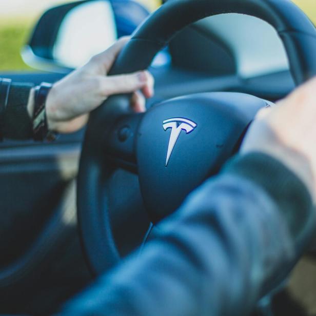 Mensch mit zwei Händen am Tesla-Lenkrad