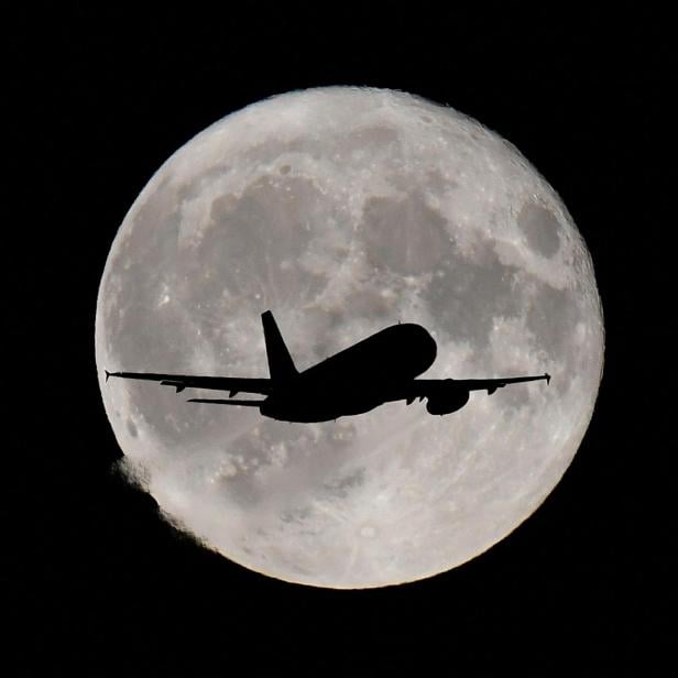 Passagierflugzeug vor dem Vollmond