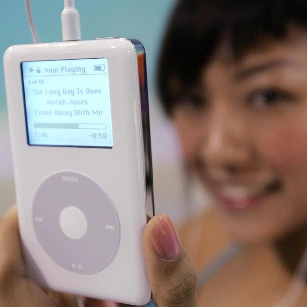 Eine Frau hält einen iPod von 2004 in die Kamera.