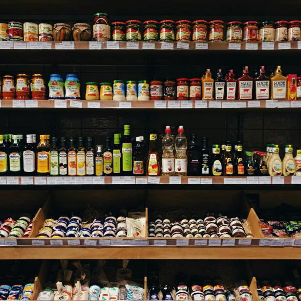 ein Supermarktregal mit Konserven in Gläsern und Olivenöl