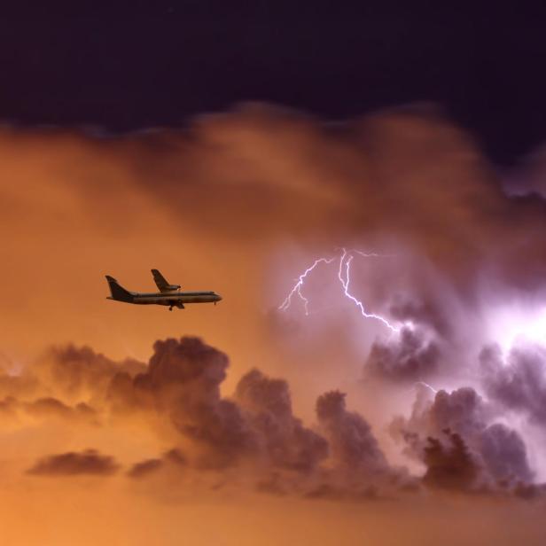 Flugzeug vor einer Gewitterwolke.
