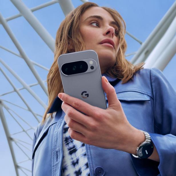 Eine Frau hält ein graues Google Pixel Smartphone in der Hand.