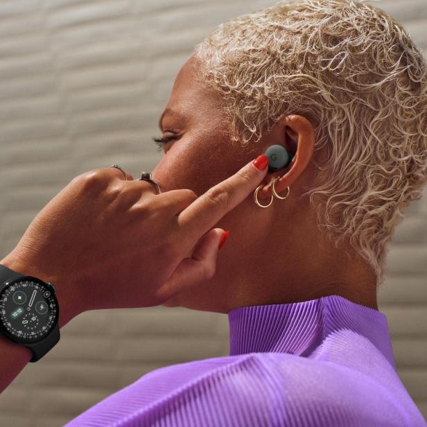 Eine Frau mit Pixel Buds im Ohr und einer Google Pixel Watch am Handgelenk.