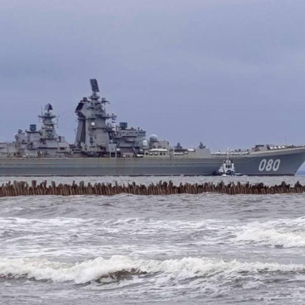 Der russische Kreuzer „Admiral Nachimow“ wird von Schleppern gezogen.
