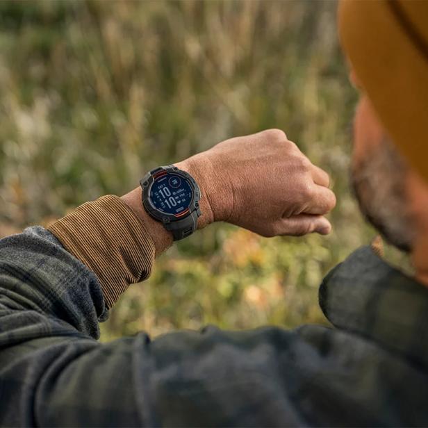 Ein Mann im Freien blickt auf seine Garmin-Smartwatch.