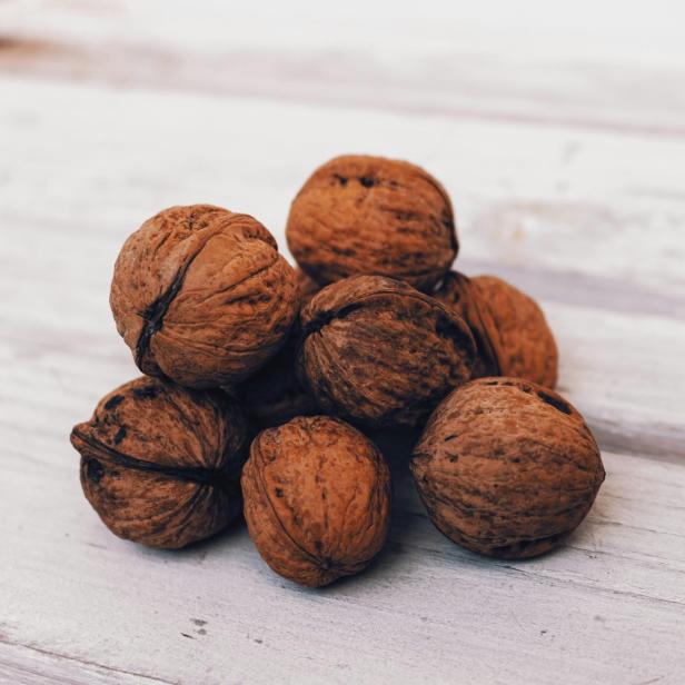 Symbolbild: Walnüsse auf Holz.