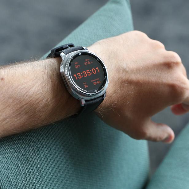 Eine Smartwatch am Handgelenk einer Person zeigt die Uhrzeit 13:35:01.