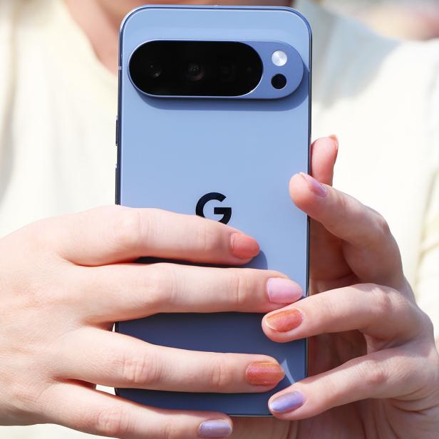 Eine Person hält ein blaues Google Pixel Smartphone in den Händen.