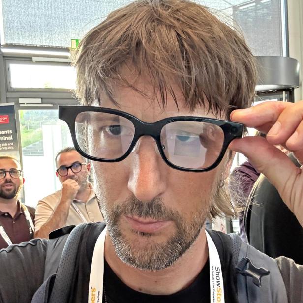 Ein Mann mit Brille der Marke Rokid auf einer Veranstaltung.