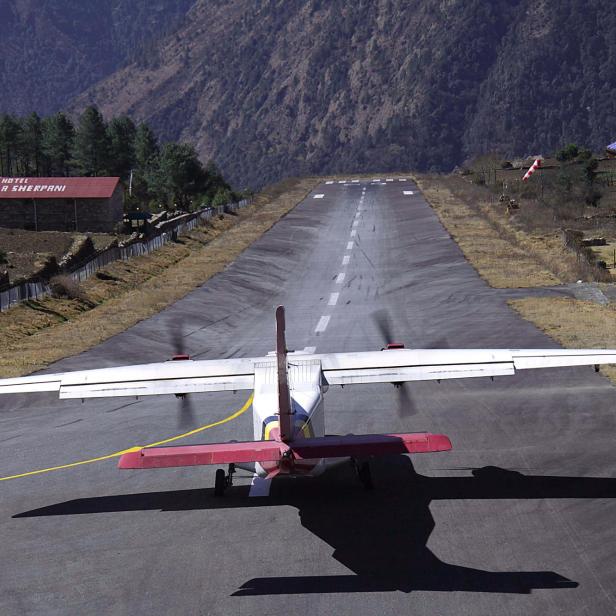 Ein Flugzeug startet auf der Landebahn des Flughafens Lukla.