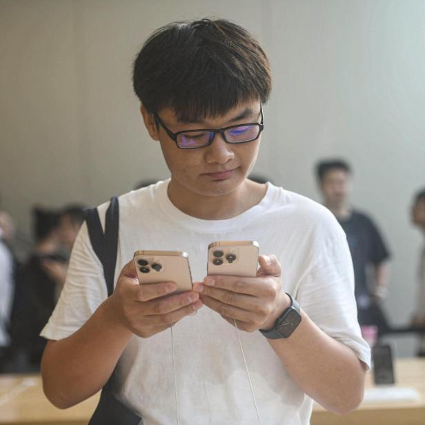 Symbolbild: Mann vergleicht iPhones in China