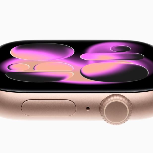 Nahaufnahme einer goldenen Apple Watch mit einem abstrakten, farbenfrohen Display.