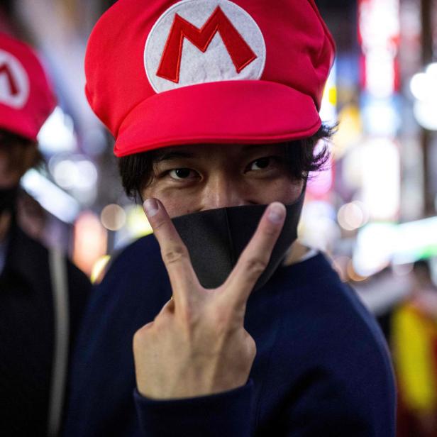 Ein Mann mit Super-Mario-Mütze zeigt ein Victory-Zeichen.