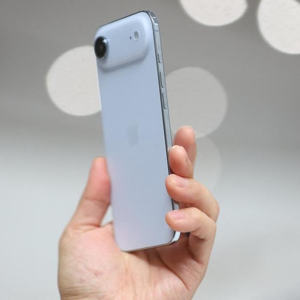 Eine Hand hält ein hellblaues Smartphone mit einer einzelnen Kamera.