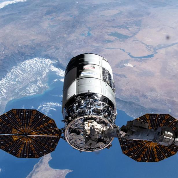 Das 21. Cygnus-Frachtschiff von Northrop Grumman, das 2024 bei der ISS angedockt ist. Zu sehen sind die Solar-Panels sowie der Greifarm.