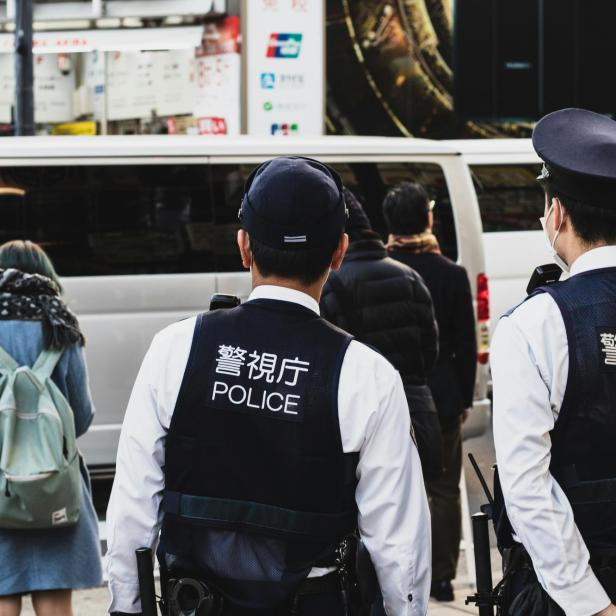 zwei japanische Polizisten blicken auf eine belebte Straße